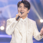 금타는 금요일 경연 무대에서 밝은 미소로 노래하는 남성 가수